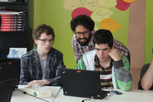 YMCA Academy teacher assisting students using a laptop