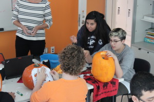 YMCA Academy students carving pumpkins