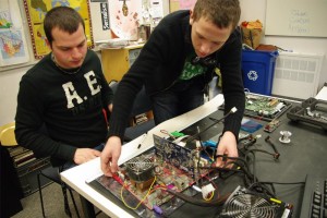 YMCA Academy student and teacher assembling a computer